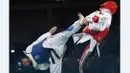  Atlet Thailand, Phannapa Harnsujin (kiri), melakukan tendangan ke arah atlet Iran, Kimia Alizadeh Zenoorin, dalam laga taekwondo kelas -57kg putri Olimpiade Rio 2016 di Carioca Arena 3, Rio de Janeiro, (18/8/2016). (AFP/Kirill Kudryavtsev)