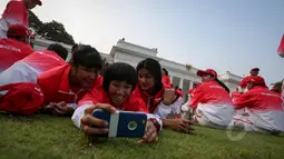 Sejumlah atlet berselfie di rumput depan Istana Merdeka, Jakarta, Selasa (26/5/2015). Kontingen Indonesia akan ditemani 226 pelatih dan satu orang Chief de Mission (CdM), dua wakil CdM, serta 32 staf kontingen. (Liputan6.com/Faizal Fanani)