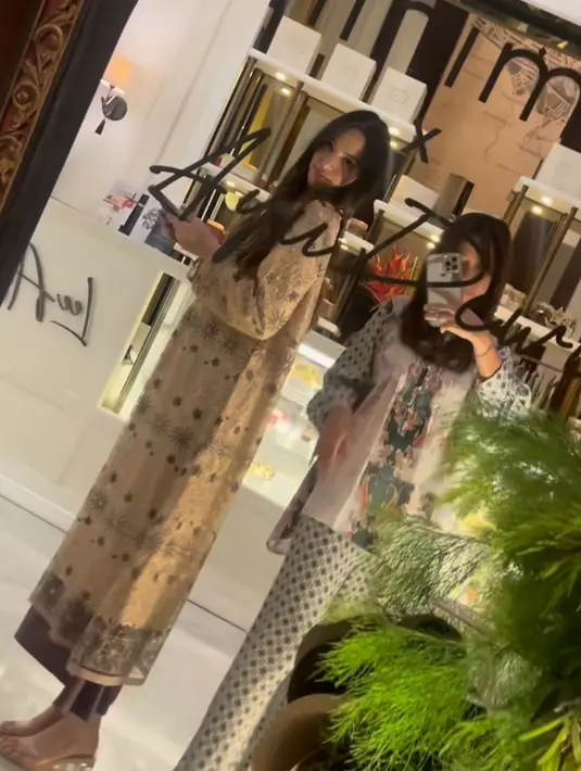 Nia Ramadhani tampil dengan nuansa earth tone. Ia mengenakan long dress coklat corak hitam dipadukan celana hitam dan heels transparan. @gitajanu