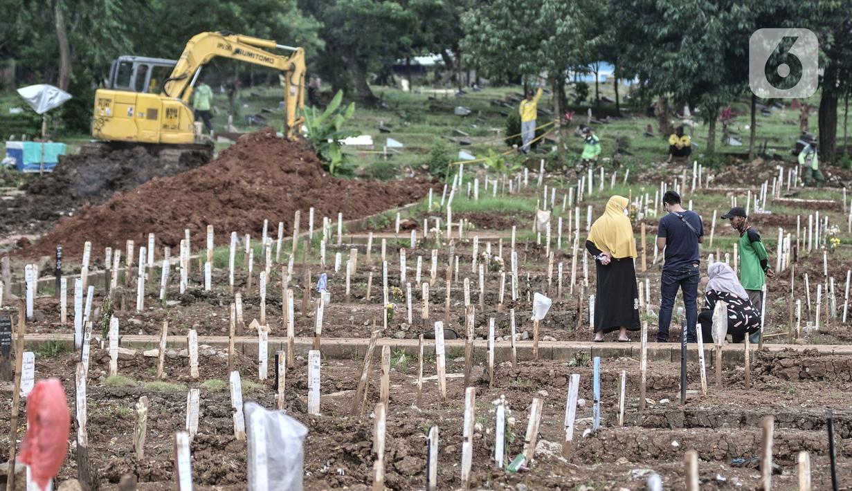 Warga berziarah ke makam kerabat di kompleks pemakaman protokol Covid-19, TPU Bambu Apus, Jakarta, Selasa (2/3/2021). TPU Bambu Apus kini tidak lagi menampung pemakaman jenazah protokol Covid-19 akibat lahan di dua blok sudah penuh dan dialihkan ke TPU Srengseng Sawah. (merdeka.com/Iqbal S Nugroho)