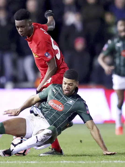 Pemain Plymouth Argyle, Jake Jervis (bawah) saat berebut bola dengan pemain Liverpool, Oviemuno Ejaria pada babak ketiga Piala FA di Home Park, Plymouth, (18/1/2017).  Liverpool menang 1-0. (Andrew Matthews/PA via AP)