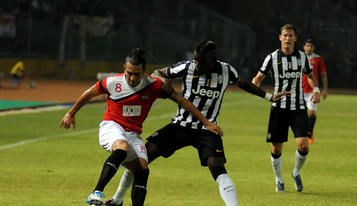 Gelandang Juventus, Paul Pogba (tengah) mencoba merebut bola dari Gustavo Lopez (ISL All Stars) saat berlaga di Stadion GBK Jakarta, (6/8/2014). (Liputan6.com/Helmi Fithriansyah)