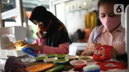 Perajin menyelesaikan pembuatan masker batik di Butik Elemwe, Jakarta, Jumat (2/10/2020). Badan Standardisasi Nasional (BSN) mengeluarkan spesifikasi masker kain ber-SNI yang terbagi menjadi tiga tipe berdasarkan penggunaannya. (Liputan6.com/Faizal Fanani)