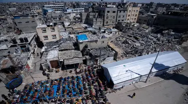 Warga Palestina melaksanakan salat Jumat pertama di bulan suci Ramadan di dekat reruntuhan masjid yang hancur akibat serangan udara Israel di Rafah, Jalur Gaza, Jumat, 15 Maret 2024. (AP Photo/Fatima Shbair)