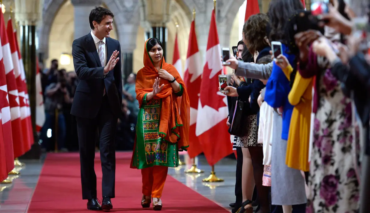PM Kanada Justin Trudeau dan aktivis muda pemenang Penghargaan Nobel Perdamaian, Malala Yousafzai saat akan menghadiri upacara pemberian hadiah kewarganegaraan di Gedung Parlemen Kanada di Ottawa, Rabu (12/4). (Justin Tang/The Canadian Press via AP)