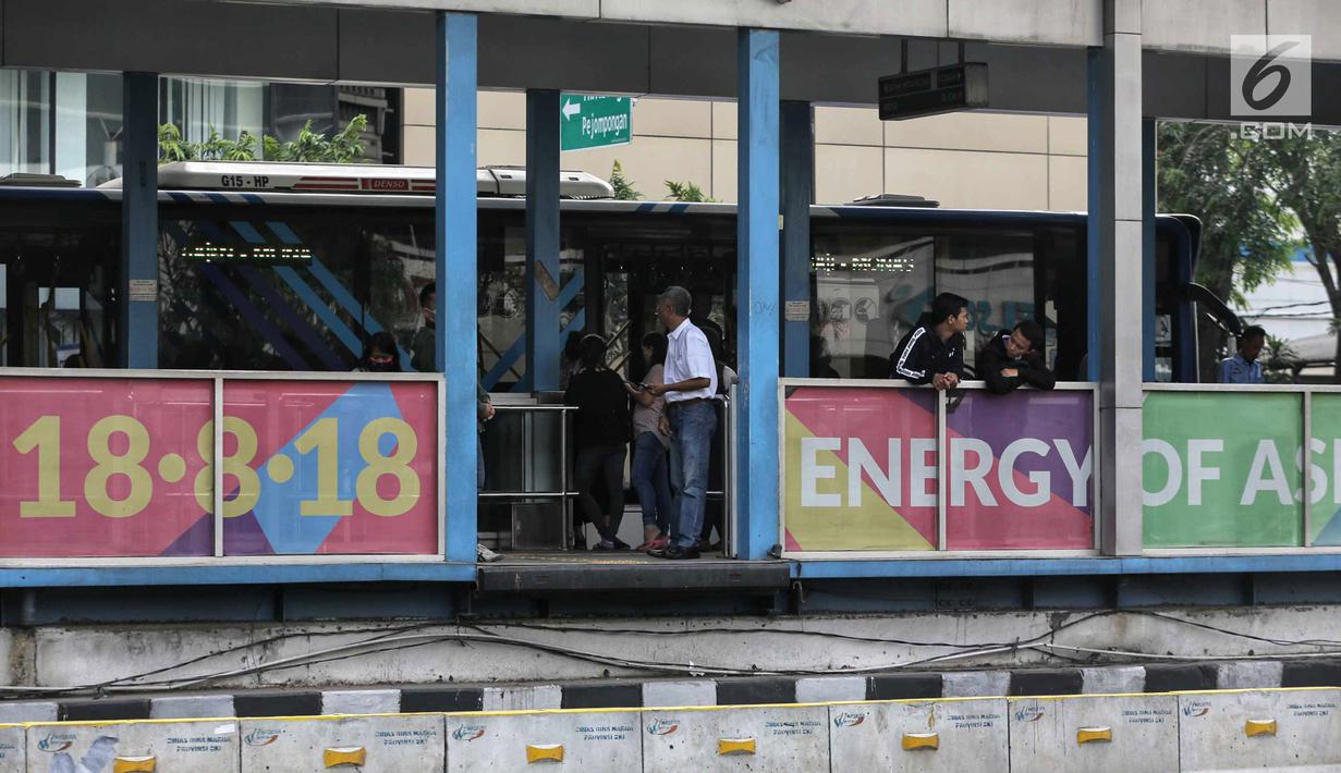 Penumpang menunggu bus Transjakarta di Jalan MH Thamrin, Jakarta, Senin (24/7). Pemprov DKI Jakarta menyiapkan 350 unit bus gratis dengan jumlah 13 ribu penumpang untuk menyambut Asian Games 2018. (Liputan6.com/Faizal Fanani)