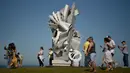 Pengunjung berjalan dekat sebuah patung bagian dari pameran Sculpture by the Sea di Sydney, Australia, Jumat (19/10). Dalam pameran ini, tak kurang dari 100 patung dengan berbagai ukuran dan bentuk menghiasi sepanjang bibir pantai. (PETER PARKS/AFP)