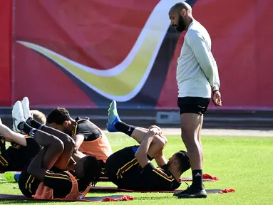Asisten pelatih Belgia Thierry Henry (kanan) melihat para pemainnya berlatih selama sesi pelatihan tim di Stadion Guchkovo di Dedovsk, Moskow, (8/7). Belgia akan bertanding pada semifinal Piala Dunia 2018 melawan Prancis. (AFP Photo/Franck Fife)