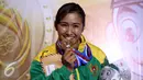 Karateka Jawa Timur, Sisilia Agustiani menggigit medali emas usai memenangi laga final Kata Putri PON XIX di GOR Sabuga, Bandung, Minggu (18/9). Di final, Sisilia berhasil mengungguli karateka Jawa Barat, Yulianti. (Liputan6.com/Helmi Fithriansyah)
