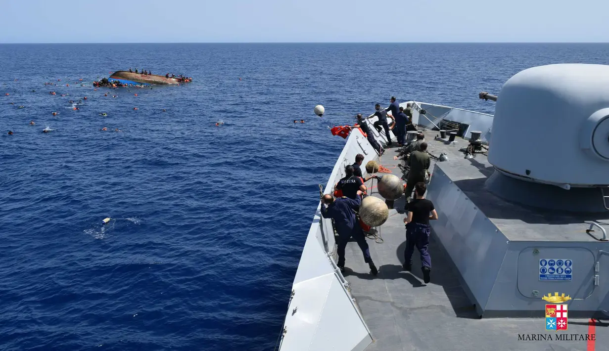 Angkatan Laut (AL) Italia merilis gambar ketika perahu yang berisi para migran terbalik di lepas pantai Libya, Rabu (25/5). Tujuh orang tewas tenggelam, sementara 500 orang lainnya berhasil diselamatkan dalam insiden tersebut (STR/AFP MARINA MILITARE/AFP)