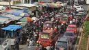 Sejumlah kendaraan berjalan merayap saat melintasi Pasar Tumpah di Cikarang, Jawa Barat, Jumat (1/7). Selain banyaknya persimpangan, keberadaan Pasar Tumpah menjadi salah satu penyebab kemacetan di Jalur Pantura. (Liputan6.com/Gempur M Surya)