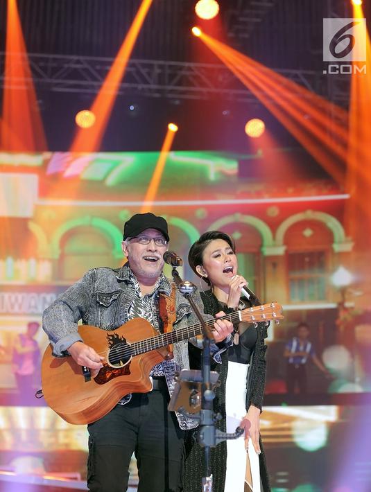 Penyanyi Iwan Fals ngedance bareng Agnes Monica alias Agnez Mo saat Konser Raya 24 Tahun Indosiar Luar Biasa di JCC Senayan, Jakarta, Jumat (11/1). Iwan Fals dan Agnez Mo menampilkan kolaborasi apik lewat duet mereka. (Fimela.com/Bambang Eros)