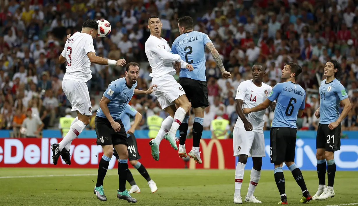Pemain Portugal, Pepe (kiri) mencetak gol lewat sundulan ke gawang Uruguay pada laga 16 besar Piala Dunia 2018 di Fisht Stadium, Sochi, Rusia, (30/6/2018). Portugal kalah 1-2. (AP/Francisco Seco)