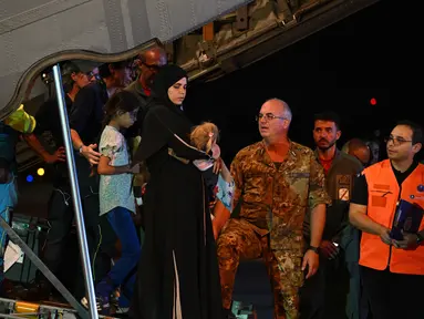 Petugas medis dan tenaga kesehatan menyambut anak-anak Palestina dari Gaza beserta keluarga mereka, setelah pesawat militer Italia C130J dari Israel mendarat pada 14 Agustus 2025 di Bandara Ciampino, Roma. (Andreas SOLARO/AFP)