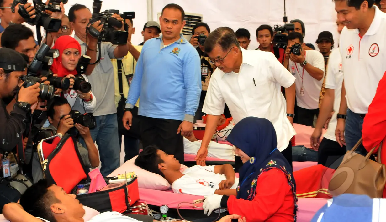Wakil Presiden Jusuf Kalla (tengah) berbincang dengan salah satu pendonor darah di Bundaran HI, Jakarta, Minggu (29/3/2015). Acara donor darah diadakan serentak di 25 kota di tanah air bertujuan membudayakan aksi donor darah. (Liputan6.com/Panji Diksana)