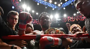 Petinju Filipina Manny Pacquiao merayakan kemenangannya usai melawan petinju Argentina, Lucas Matthysse pada kelas welter versi WBA di Axiata Arena di Kuala Lumpur, Malaysia (15/7). Pacquiao menang KO atas Matthysse di Ronde ke 7. (AFP Photo/Mohd Rasfan)