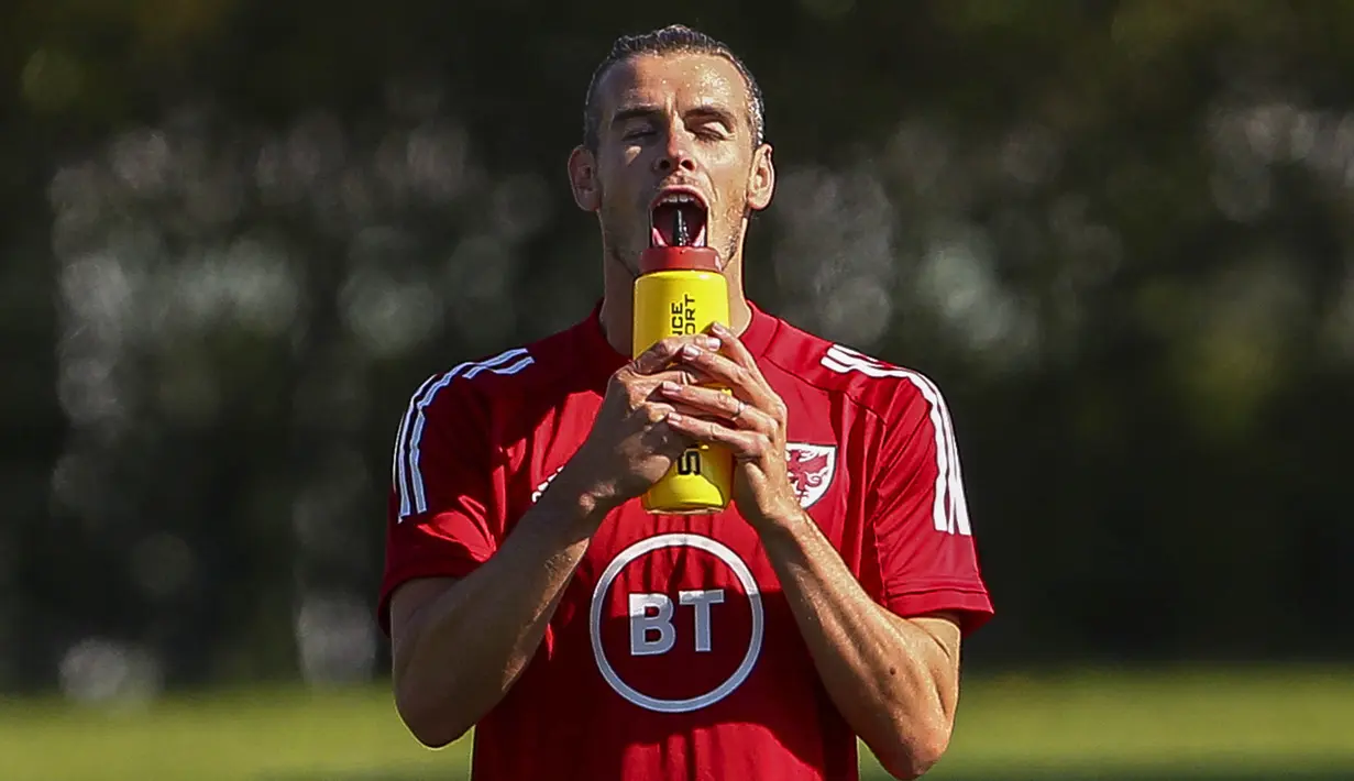 Pemain Timnas Wales, Gareth Bale, minum saat mengikuti latihan jelang laga UEFA Nations League di Hensol, South Wales, Senin (31/8/2020). Wales akan berhadapan dengan Finlandia. (AFP/Geoff Caddick)