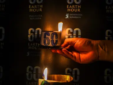 Seorang aktivis menyalakan lilin dalam sebuah acara untuk menandai kampanye lingkungan Earth Hour di Surabaya pada 23 Maret 2024. (JUNI KRISWANTO/AFP)