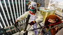 Petugas Pembersih jendela mengenakan kostum domba dan monyet saat membersihkan jendela lantai 15 sebuah hotel di Tokyo, Jepang, (21/12). Mereka mengenakan kostum mencerminkan shio hewan pada kalender Cina. (REUTERS/Thomas Peter)