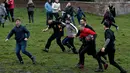 Seorang pria membawa bola saat mengikuti Royal Shrovetide Football Match di Ashbourne, Derbyshire, Inggris, Selasa (5/3). Pertandingan ini bertujuan untuk meletakkan sebuah bola ke gawang yang berjarak 3 mil (4,8 kilometer). (Oli Scarff/AFP)