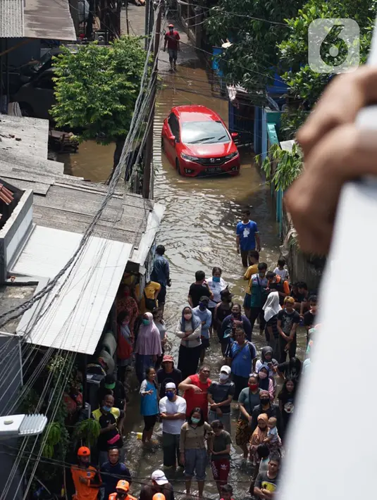 Sejumlah warga berkumpul saat banjir dan longsor di Jalan Damai, Ciganjur, Jakarta Selatan, Minggu (11/10/2020). Hujan yang deras sejak Sabtu (10/10/2020) sore mengakibatkan kawasan tersebut mengalami banjir sekaligus longsor. (Liputan6.com/Immanuel Antonius)