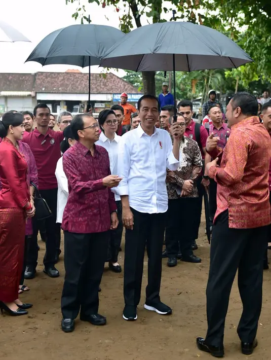 Presiden Joko Widodo mendengarkan penjelasan Bupati Gianyar Made Mahayastra tentang rencana revitalisasi Pasar Sukawati di Gianyar, Bali, Jumat (14/6/2019). Jokowi yang ditemani Ibu Negara Iriana mengawali kunjungan kerja ke Bali dengan meninjau Pasar Sukawati. (Liputan6.com/Pool/Biro Pers Setpres)