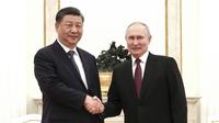 Dalam foto selebaran yang dirilis oleh Kantor Pers Kepresidenan Rusia ini memperlihatkan Presiden Rusia Vladimir Putin (kanan) dan Presiden Tiongkok Xi Jinping berjabat tangan sebelum pembicaraan mereka di Kremlin di Moskow, Senin (20/3/2023). (Russian Presidential Press Office via AP)