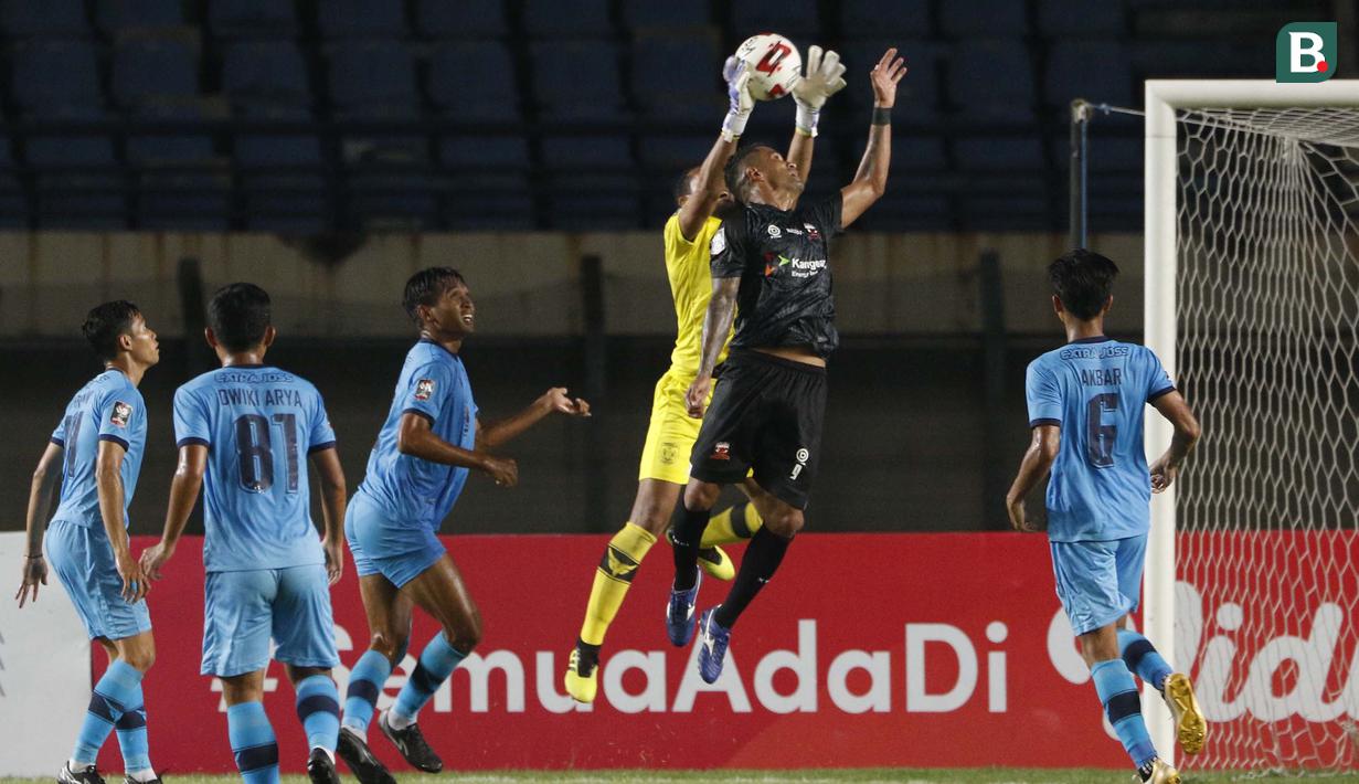 Kiper Persela Lamongan, Dwi Kuswanto (tengah) berhasil menangkap bola saat menghadapi Madura United dalam laga matchday ke-3 Grup C Piala Menpora 2021 di Stadion Si Jalak Harupat, Bandung, Kamis (1/4/2021). Persela bermain imbang 1-1 dengan Madura United. (Bola.com/Ikhwan Yanuar)