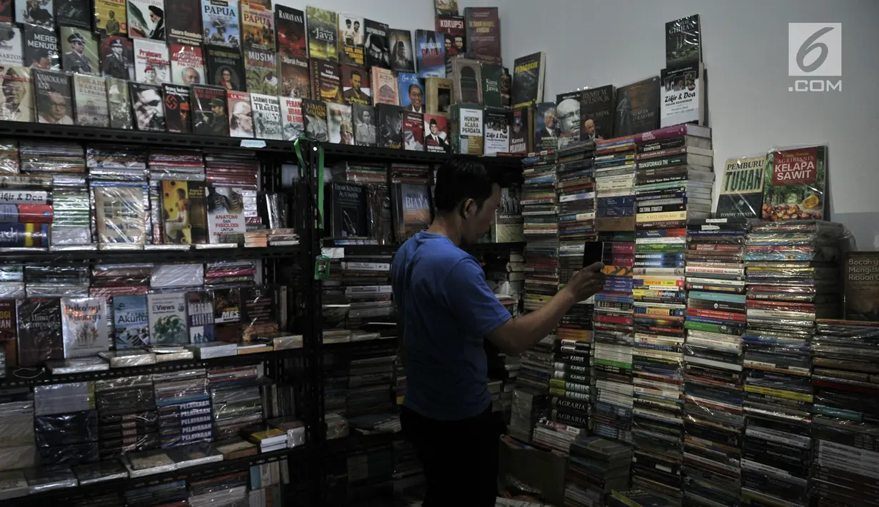 Pedagang menggunakan senter saat mencari buku di salah satu kios Wisata Buku, Pasar Kenari, Jakarta, Selasa (20/8/2019). Sentra buku tersebut hingga kini masih sepi pembeli sejak diresmikan  Gubernur DKI Jakarta Anies Baswedan 4 bulan lalu dikarenakan minimnya promosi. (merdeka.com/Iqbal S. Nugroho)