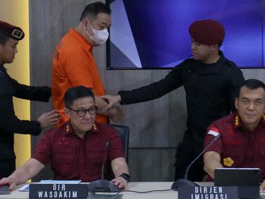 Buronan interpol berinisial LQ asal China dihadirkan pada konferensi pers Penangkapan Buronan Internasional di Dirjen Imigrasi, Jakarta, Kamis (10/10/2024). (Liputan6.com/Herman Zakharia)