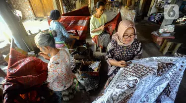 Para perajin menyelesaikan pembuatan batik tulis di Tie Poek Batik, Trenggalek, Jawa Timur, Sabtu (2/9/2023). Batik tulis corak Trenggalek didominasi bunga cengkeh. (merdeka.com/Arie Basuki)