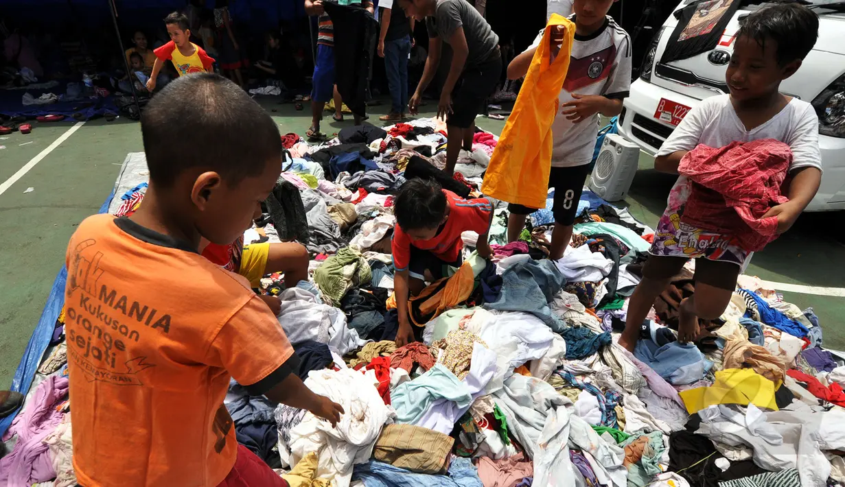 Sejumlah pengungsi mengambil baju layak pakai di posko pengungsian kebakaran di Kebon Melati, Tanah Abang, Jakarta, (6/3/2015). Kebakaran hebat pada Kamis (5/3) petang menyebabkan setidaknya 1.600 warga terpaksa mengungsi. ( Liputan6.com/Faizal Fanani)