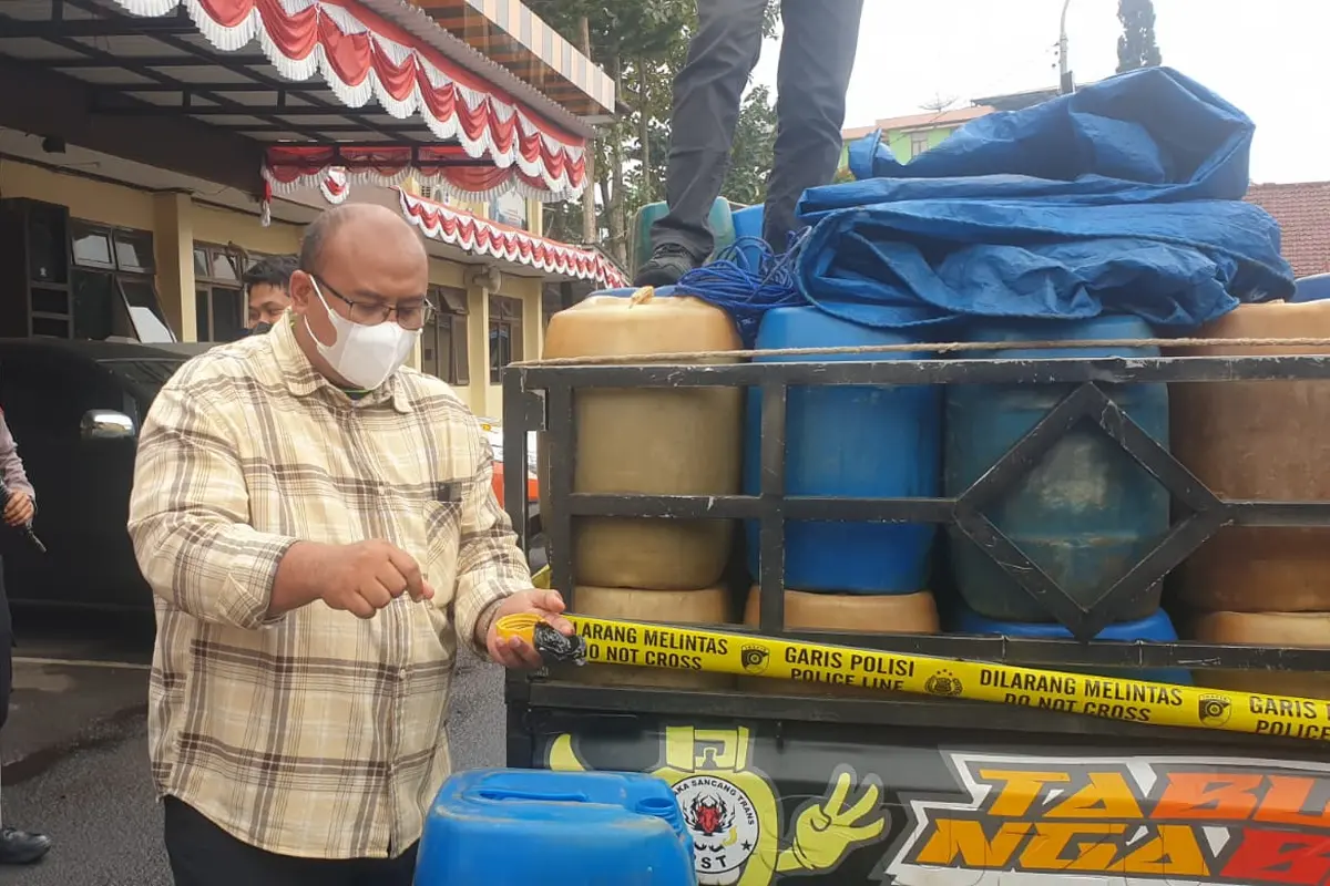 Kapolres Garut AKBP Wirdhanto Hadicaksono bersama Kasatreskrim AKP Dede Sopandi menunjukan barang bukti puluhan jerigen BBM bersubsidi hasil pengungkapan kasus. (Liputan6.com/Jayadi Supriadin)
