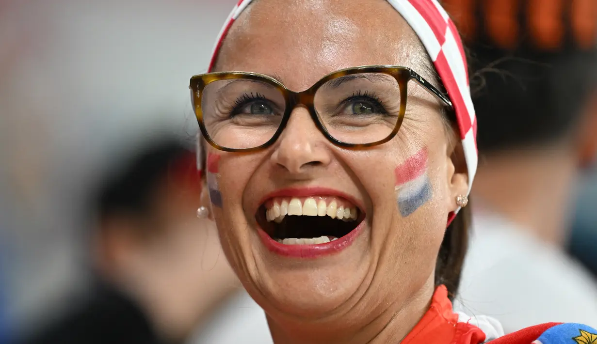 Seorang fans wanita Kroasia bersama rekannya menghadiri pertandingan Grup F Piala Dunia Qatar 2022 antara Kroasia dan Belgia di Stadion Ahmad Bin Ali di Al-Rayyan, barat Doha pada 1 Desember 2022. (AFP/Ozan Kose)