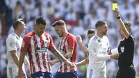 Wasit Xavier Estrada memberikan kartu kuning kepada gelandang Real Madrid, Toni Kross, saat melawan Atletico Madrid pada laga La Liga Spanyol di Stadion Santiago Bernabeu, Madrid, Minggu (8/4/2018). Kedua klub bermain imbang 1-1. (AFP/Gabriel Bouys)