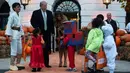 Presiden Amerika Serikat (AS) Donald Trump dan Ibu Negara Melania Trump membagikan permen kepada anak-anak selama yang hadir acara trick-or-treat pada perayaan Halloween di Gedung Putih, Washington, Minggu (28/10). (NICHOLAS KAMM / AFP)