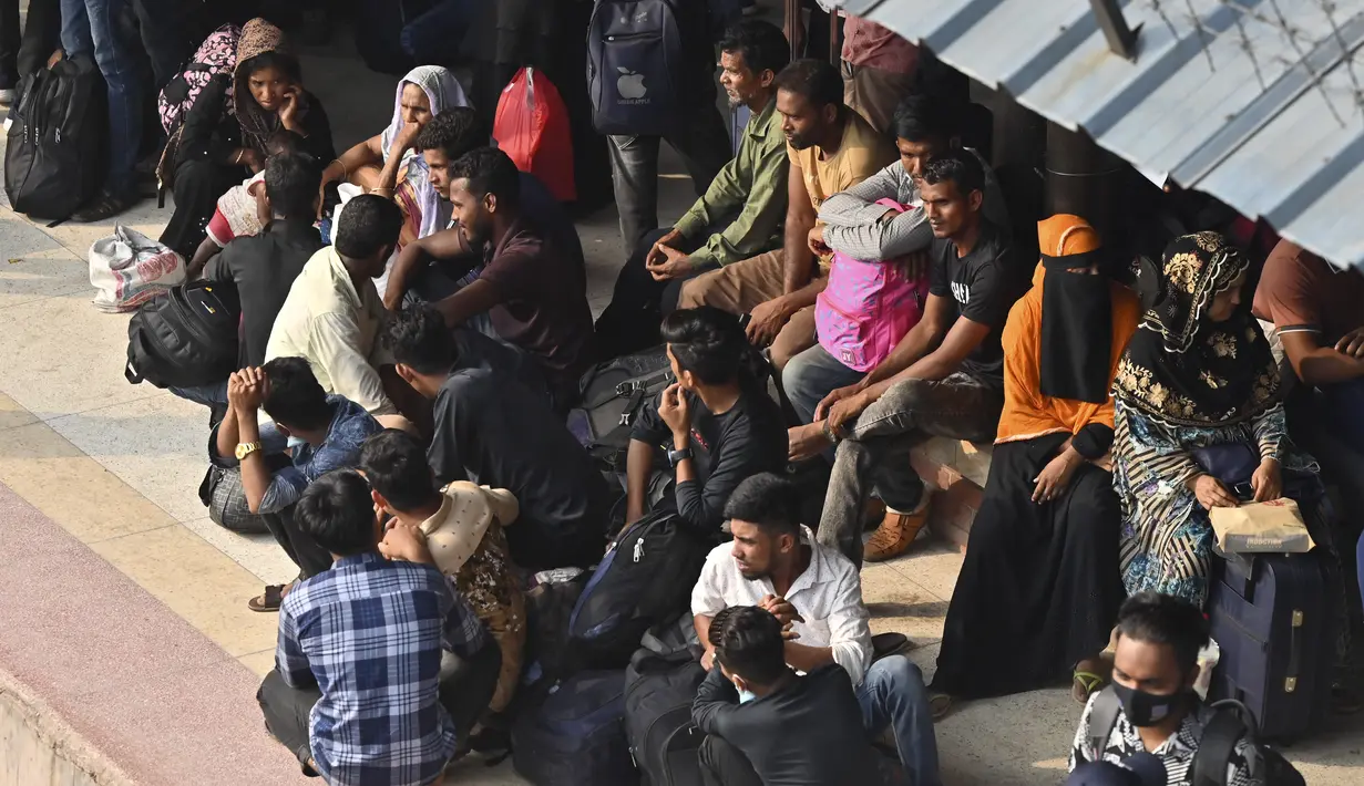 <p>Orang-orang yang pulang untuk merayakan Idul Fitri, yang menandai berakhirnya bulan suci Ramadhan, menunggu di peron untuk naik kereta api di stasiun kereta Bandara Dhaka di Dhaka pada 29 April 2022. (AFP/Munir uz Zaman)</p>