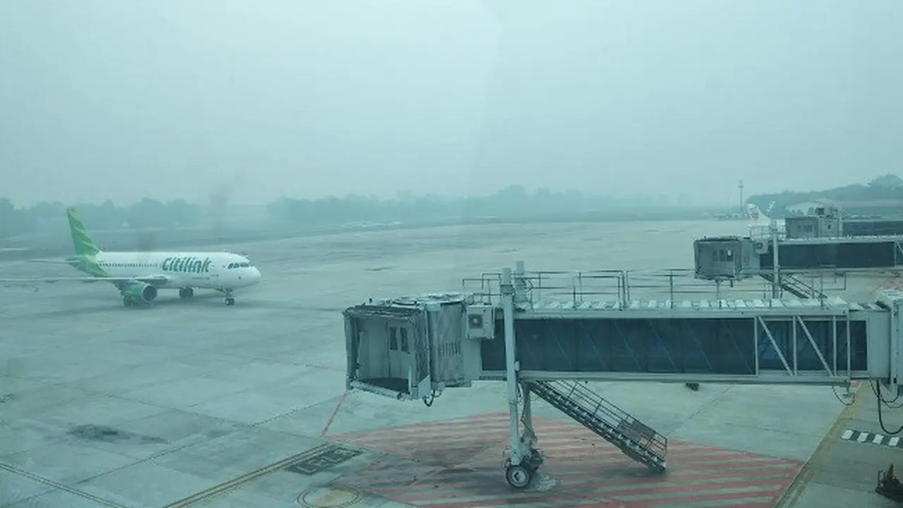Pesawat Citilink mendarat di Bandara SSK II Pekanbaru yang diselimuti kabut asap tebal.