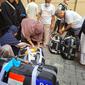 Jemaah haji dari Embarkasi PDG 2 menimbang koper, Kamis (14/7/2022) (Liputan6.com/ Mevi Linawati)