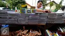 Seorang pedagang tampak merapikan barang dagangannya, Jakarta, Minggu (26/7/2015). Jelang tahun ajaran baru 2015/2016, penjualan buku tulis dan perlengkapan sekolah diperkirakan terus meningkat hingga Agustus mendatang. (Liputan6.com/Yoppy Renato)