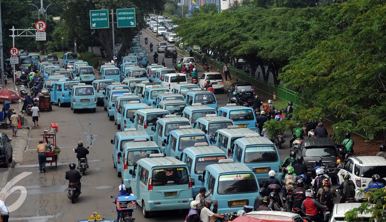 Puluhan mikrolet M 44 jurusan Kampung Melayu-Karet berderet menutupi persimpangan jalan layang KH Abdulah Syafei, Jakarta, Rabu (25/5). Menurut pengemudi, aksi ini bentuk protes tindakan penderekan mobil rekan mereka. (Liputan6.com/Helmi Fithriansyah)