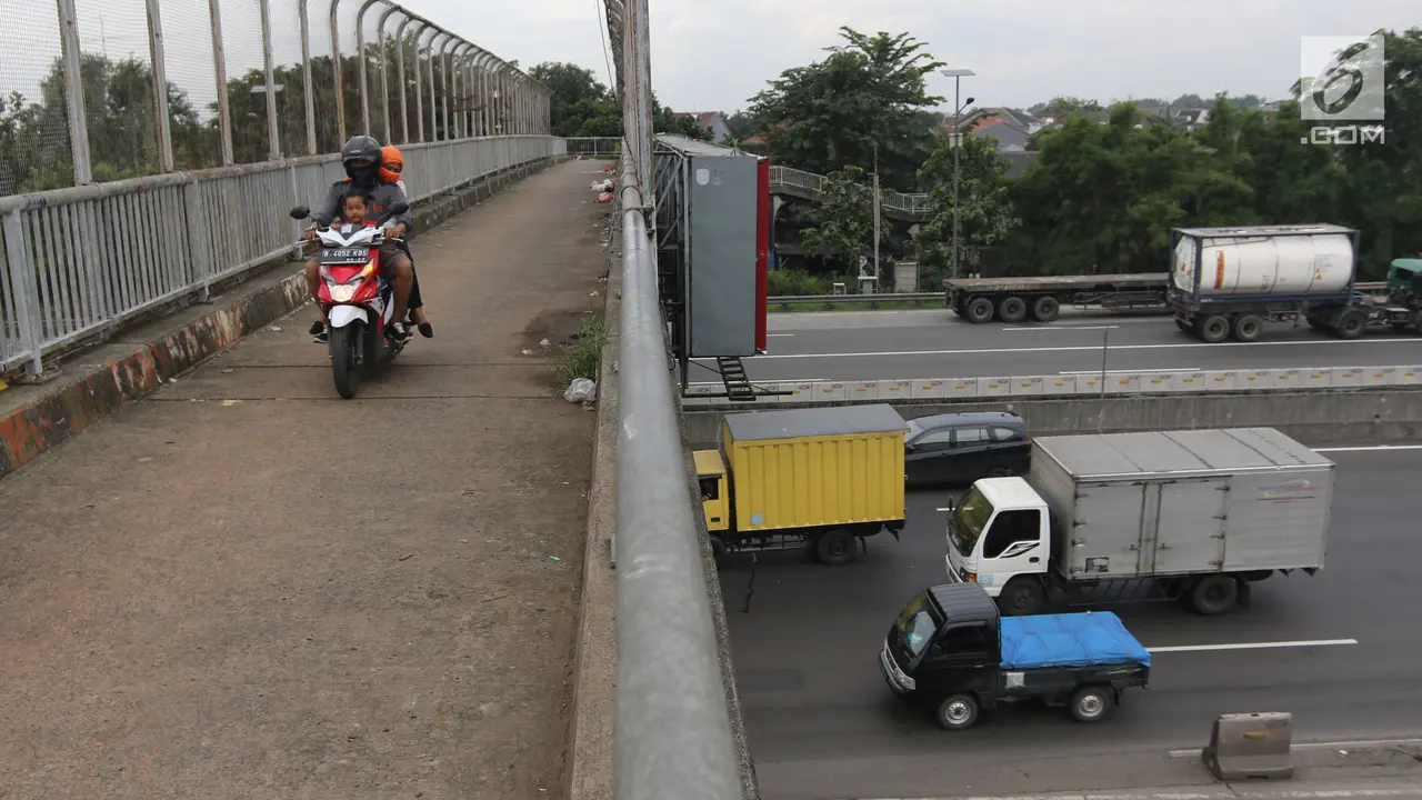 Pengendara Motor Melintas di Jembatan Penyeberangan