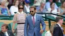 Pippa Middleton ditemani adiknya, James Middleton, menuju kursi untuk menyaksikan kejuaraan tenis Grand Slam Wimbledon 2017 di London, Rabu (5/7). Pippa hadir dalam balutan mini-dress berwarna dusty pink dari label Self-Potrait. (AP Photo/Tim Ireland)