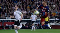 Penyerang Barcelona, Neymar (kanan) berusaha mengontrol bola dari kejaran pemain Valencia di pertandingan liga Spanyol di Camp Nou stadium (18/4). Valencia menang atas Barcelona dengan skor 2-1. (AFP PHOTO/ JOSEP LAGO)