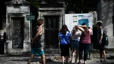 Turis melihat peta pemakaman Pere Lachaise sebelum memulai kunjungan mereka di Paris (22/7/2019). Pemakaman Père adalah salah satu pemakaman terbesar di Paris (luasnya sekitar 44 hektar 110 acre). (AFP Photo/Philippe Lopez)