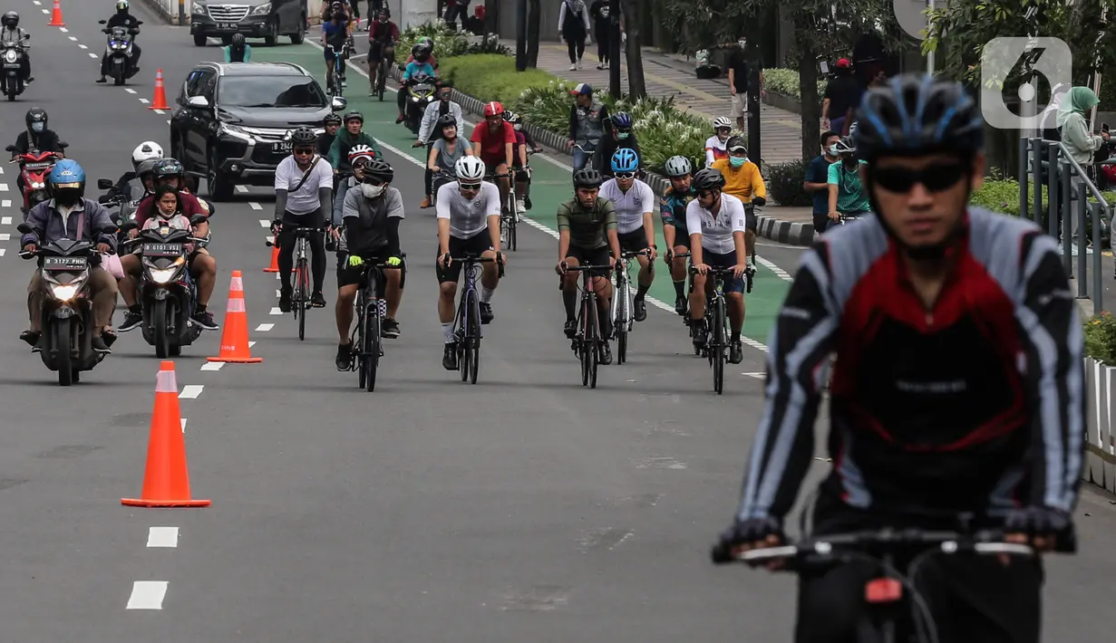 Warga bersepeda melintasi kawasan Sudirman - Thamrin saat akhir pekan, Jakarta, Minggu (20/2/2022). Aktivitas warga di kawasan tersebut relatif ramai saat Pemberlakuan Pembatasan Kegiatan Masyarakat (PPKM) level tiga di ibu kota. (Liputan6.com/Johan Tallo)