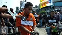 Tersangka saat rekonstruksi pembunuhan dan pencurian juragan beras Mamat Syurohmat yang terjadi pada 21 Maret lalu di Ciracas, Jakarta, Kamis (17/6/2015). Tujuh orang pelaku memperagakan 20 adegan rekonstruksi. (Liputan6.com/Yoppy Renato)