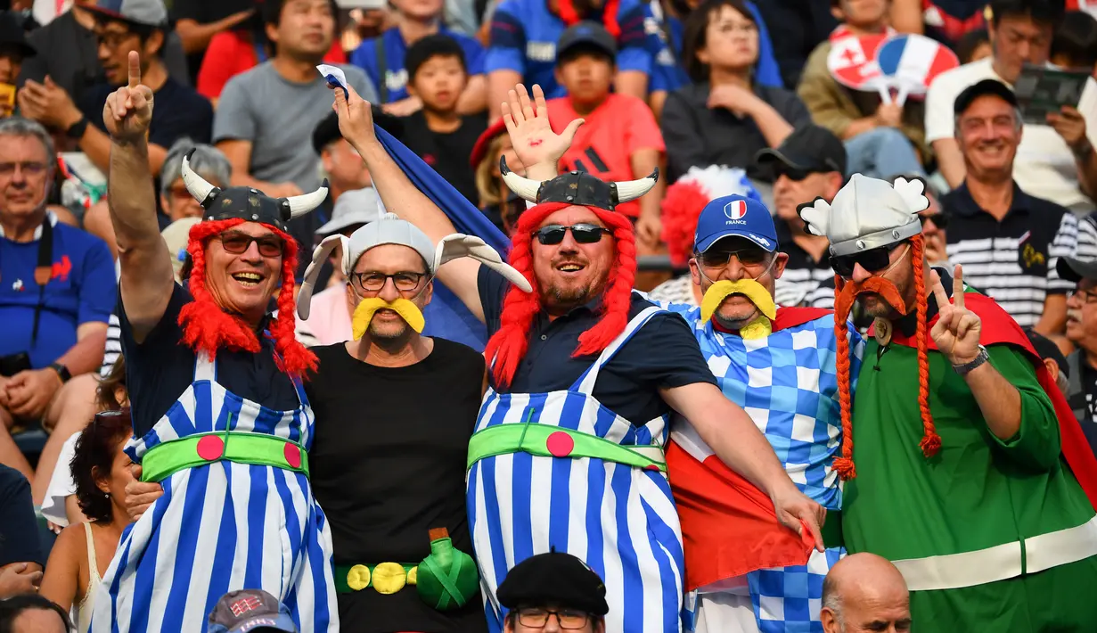Fans Prancis mengenakan kostum Asterix Obelix berpose sebelum pertandingan Rugby World Cup Pool C antara Prancis dan Tonga di Stadion Kumamoto di Kumamoto (6/10/2019). (AFP Photo/Gabriel Bouys)