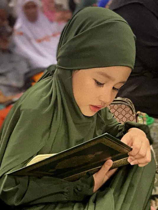 Saat mengaji Khalisa terlihat begitu fokus. Ia pun tampil dengan abaya dan kerudung panjang warna hijau. [@kartikaputriworld]