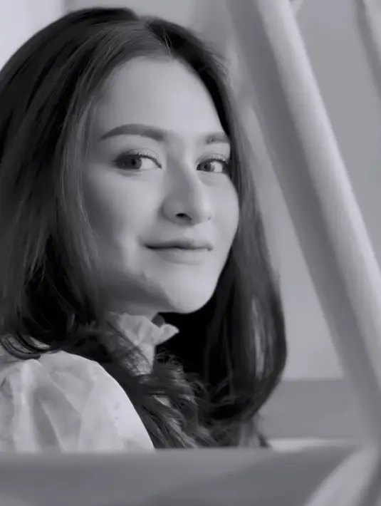 Ibu satu anak ini terlihat melepas hijabnya dari unggahan instagram putih hitamnya. Dalam video, awalnya terlihat perempuan dengan rambut tergerai sedang membuka pintu kamar.  (@nathalieholscher)